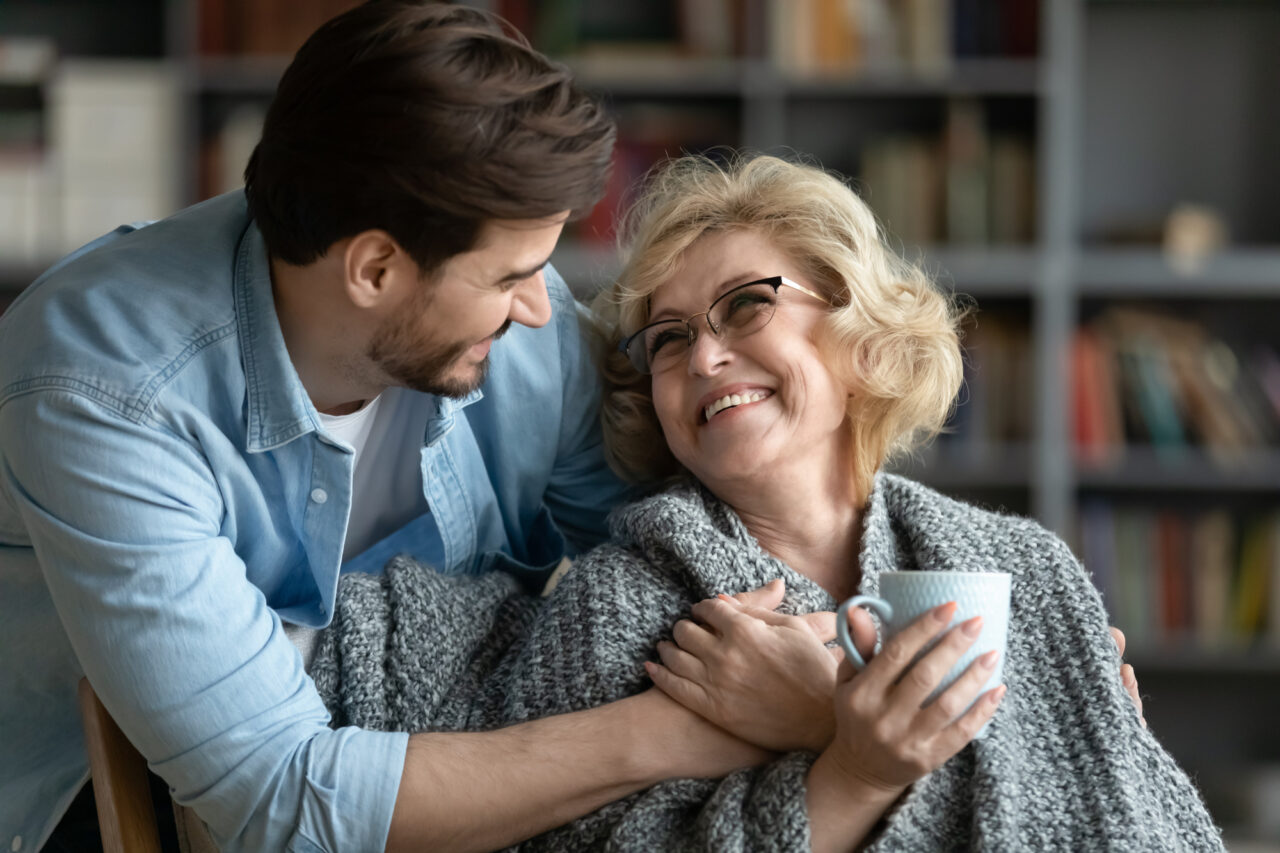 Happy young man taking care of elderly happy mother.