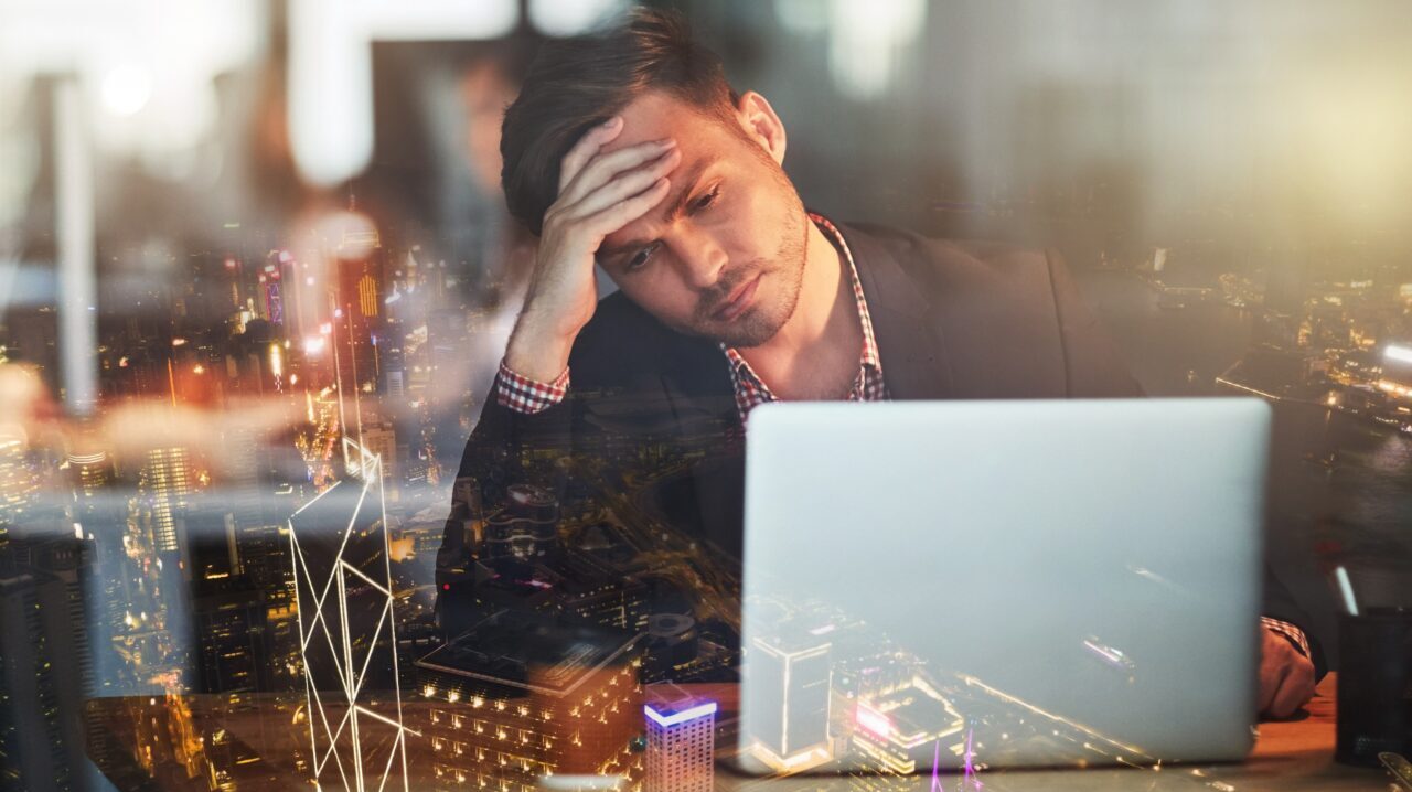 Sad stressed tired man looking at laptop.