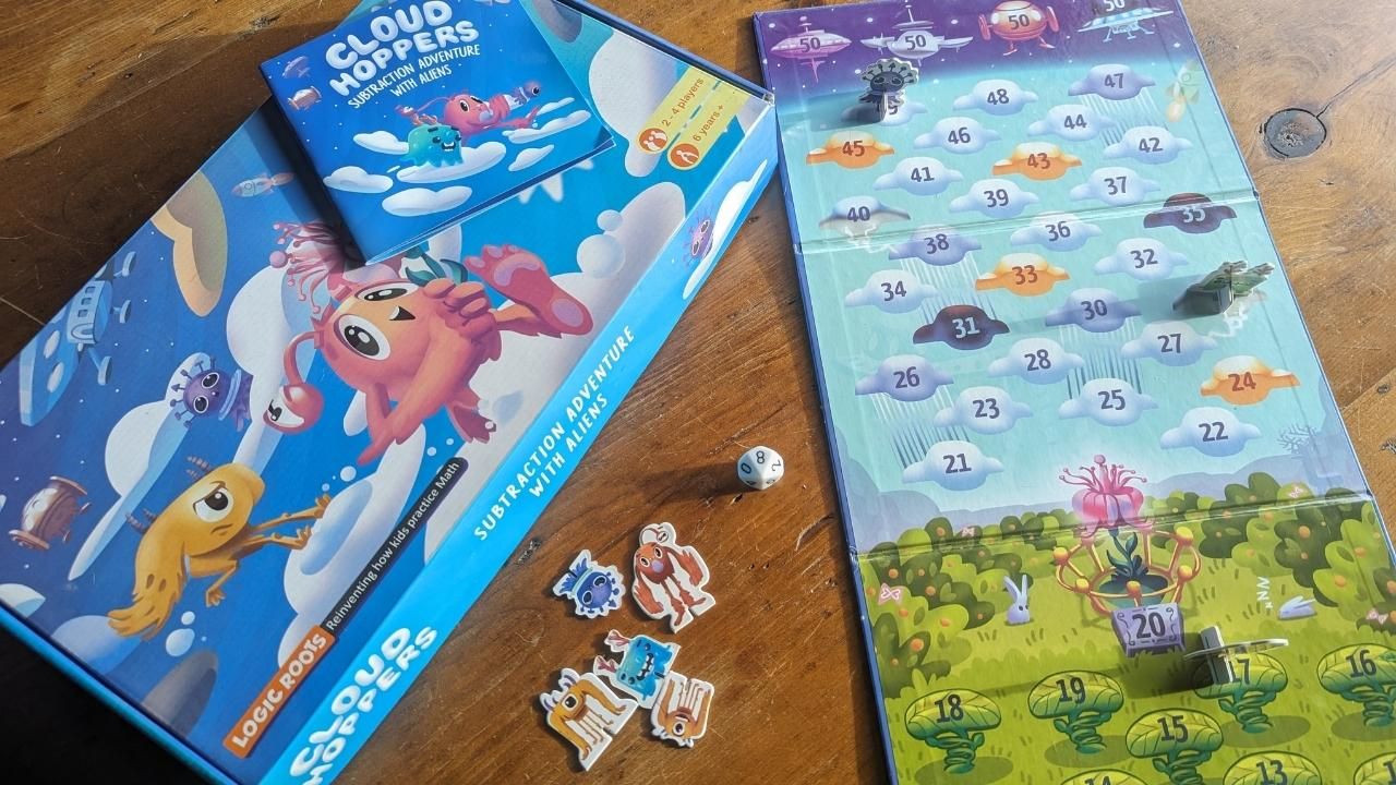 Cloud Hopers Math Board Game with cute aliens Spread out on a table.