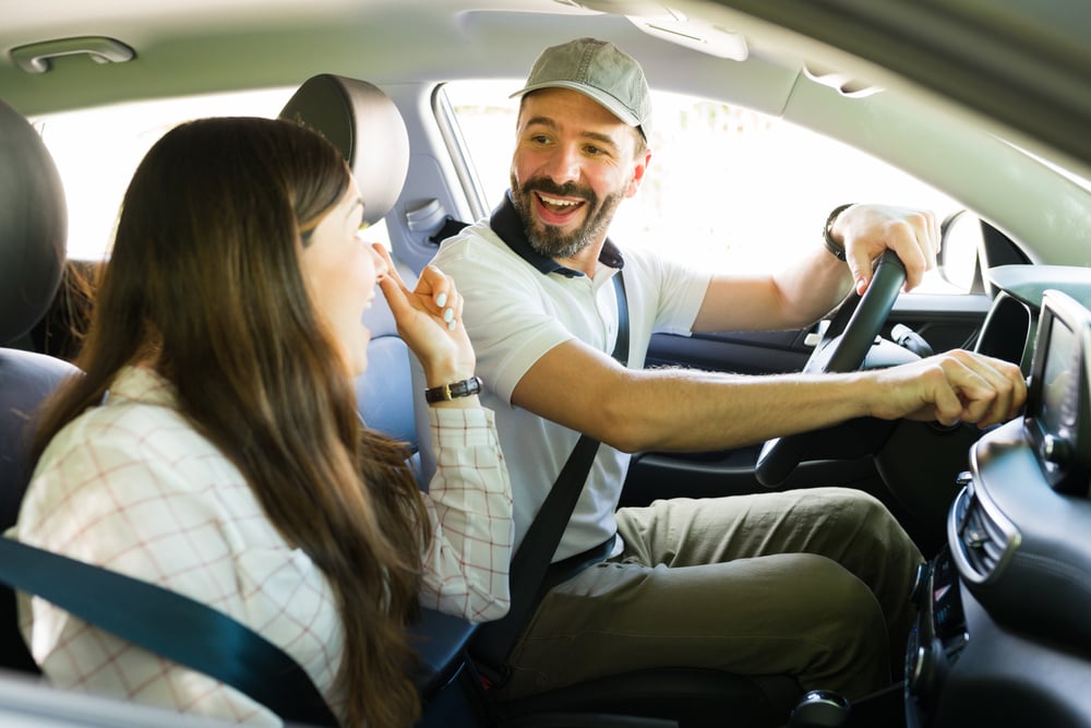 Happy man in a car talking with wife