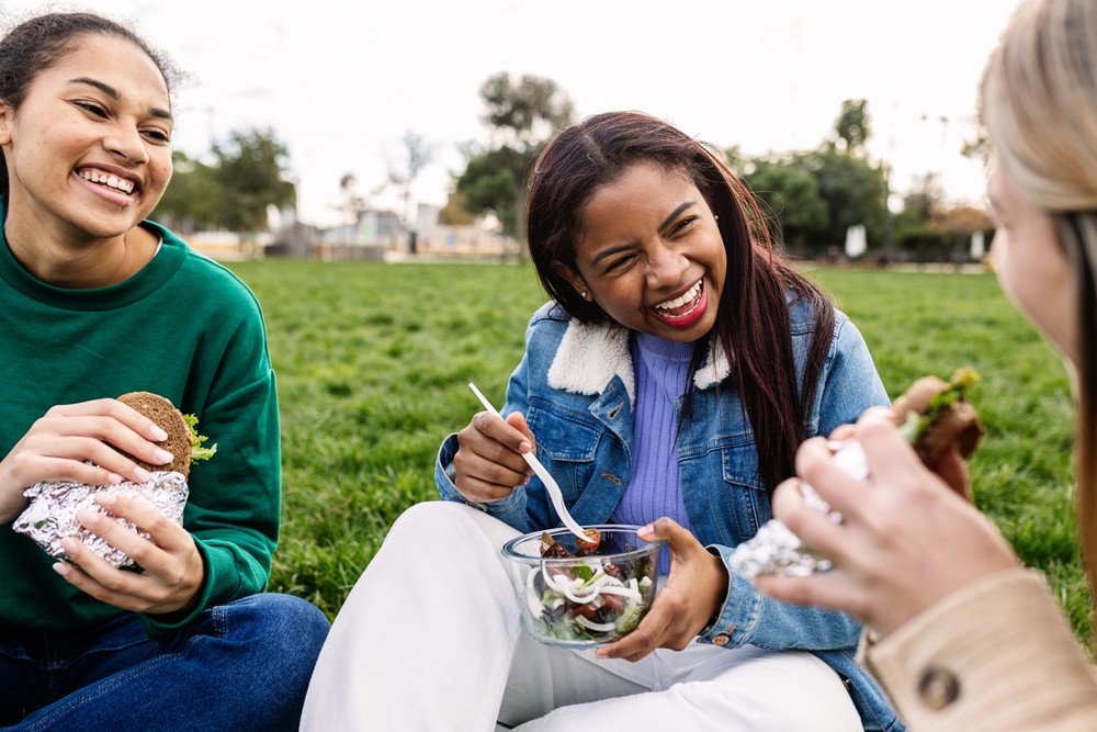 teens sit together eating lunch