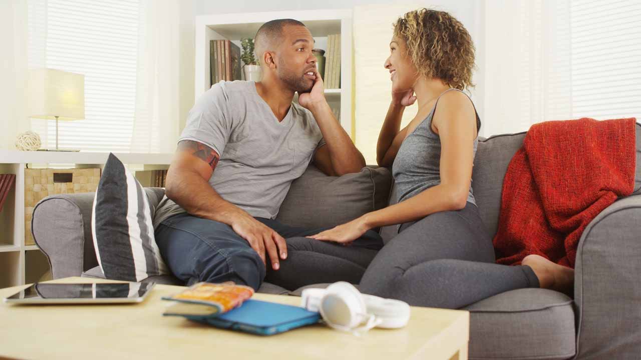 Couple facing each other, looking each other in the eye, to have a serious discussion.