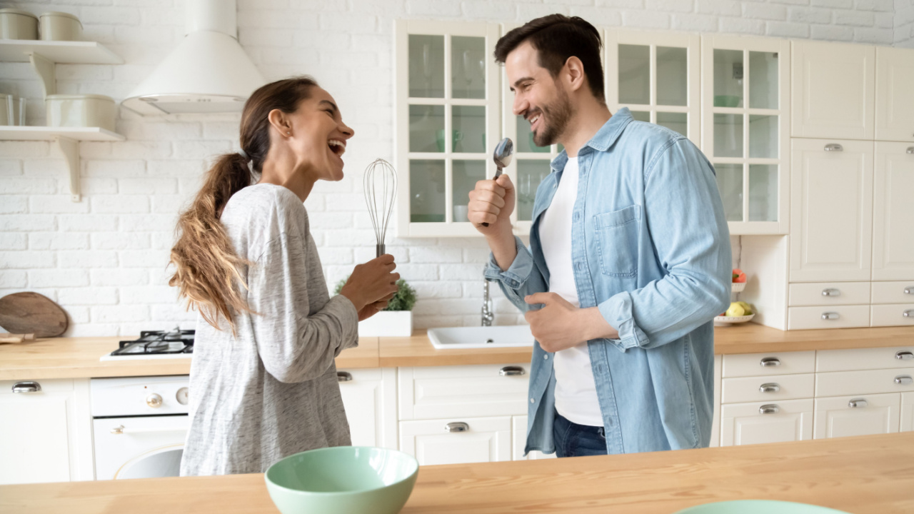 couple singing together in the kitchen.